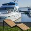 Saint Tropez liggestol ved havnen med yacht i baggrunden.