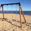 Gyngestativ til 2 sæder på sandstrand med havudsigt.