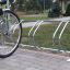Cykelstativ til 4 cykler installeret på flisebelagt område.