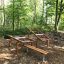Udendørs bænk i stålkonstruktion placeret i naturrig park.