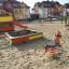 Sandkasse med legeudstyr i en børnevenlig park.