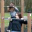 To unge kvinder træner på Trækstænger i en udendørs fitnesspark.