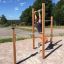 Mand træner på Trækstænger i udendørs fitnessområde.