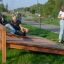 Tre unge leger på Mavebøjning Bænk i en park'