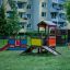 Farverig børnespillehus Hønsehuset med rutsjebane i en bypark.