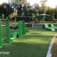 Grøn udendørs fitnessbane 'Ribbon Fitness I' i parkmiljø.