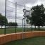 Multiarena Træ med basketballkurv ved en sø i parkområde.
