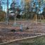 Cassiopeia klatrestativ i stål på legeplads med gynge og klatreringse.