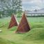 Tipi Natur trælegetelt på grønt græs ved legeplads.
