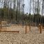 Træningsudstyr 'Klatrenet mini' i en udendørs skovpark.