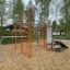 Farverigt udendørs fitnessudstyr med klatrevæg og ringe, MF Training Set, i parkområde.