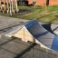Spine - Ramp legepladsudstyr på en flisebelagt gård.