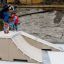 Børn observerer en skateboarder, der udfører tricks på Jump - Ramp rampe.