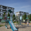 Ung opdagelsesrejsende med klatrevæg legeplads med rutschebane og klatrestativ i boligområde