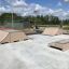 Skatepark med forskellige ramper og forhindringer under åben himmel.