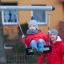 Stålgyngestativ til 2 sæder med barn på gynge og voksen i baggrunden