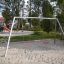 Gyngestativ i stål til 2 sæder på legeplads med sandbund.