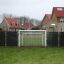 Skolegårds målvæg installeret på en grøn græsplæne foran boligområde