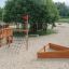 Legeplads med Robinia fiskerbåd, sandkasse og rutsjebane på sandbunden.
