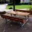 Picnic bænkebord i galvaniseret stål og lærketræ udendørs.