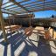Picnic bænkebord galv. stål / lærketræ placeret under træ pergola på solrig dag