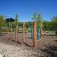 Robinia kolbøttestænger triple installeret i en legeplads med naturlige omgivelser.