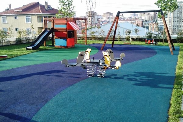 Legeplads med Wetpour Gummiasfalt 40 overflade og børnegynge i en park.