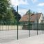 Multi Sport Ground med grønne hegn og basketballbane i skolegård