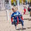 Lille pige gynger på en rød Gyngesæde babygynge på legepladsen.