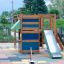 Klatrekiosken - Legehus med rutsjebane og klatrevæg på legeplads med farvet gummibelægning