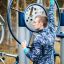 Mand bruger udendørs fitnessudstyr i parken.