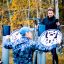 Mand og kvinde bruger udendørs fitnessudstyr i efterårslandskab.