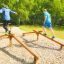 To mænd træner balance på en Forhindringsbom i en park.