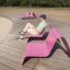 Mand sidder på moderne pink Lounge stol i udendørs parkområde.