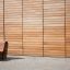 Sofa Wave udendørs bænk (lærk) placeret mod træbeklædt væg