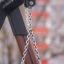 Detaljeret billede af kædeophæng på legetårn med dækgynge, sikret med bælter og metalkoblinger.